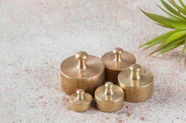 Beton arka planda pullar için beş antika bronz ağırlık. Metin ve yemek fotoğrafçılığı için alanı kopyala.