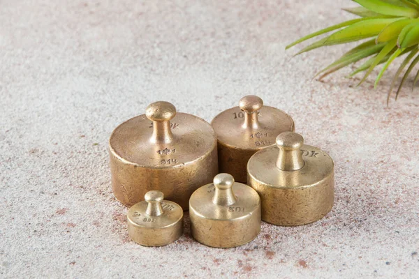 Five antique bronze weights for scales on concrete background. Copy space for text and food photography props.