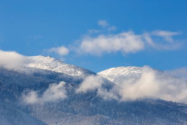 Güzel dağ zirveleri ve yumuşak beyaz bulutlar b kar kaplı