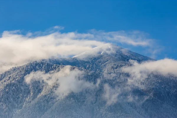 Güzel dağ zirveleri ve yumuşak beyaz bulutlar b kar kaplı