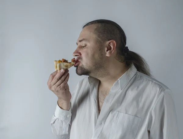 Homme mange une tranche de pizza — Photo