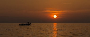 Ufukta bir tekne ile göl günbatımı