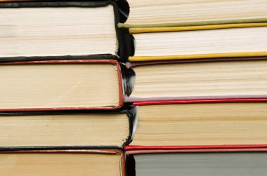 bir kitaplıktaki renkli kitap yığını