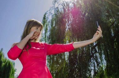 Kız selfie doğa üzerinde yapar.