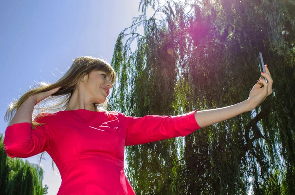 Kız selfie doğa üzerinde yapar.