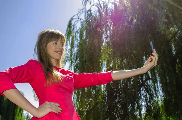 Kız selfie doğa üzerinde yapar.