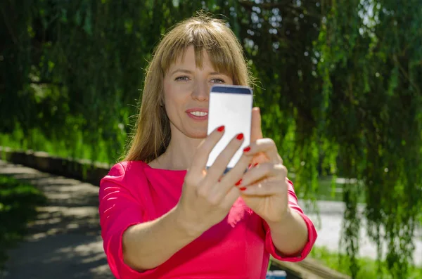 Kız selfie doğa üzerinde yapar.