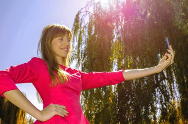 Kız selfie doğa üzerinde yapar.