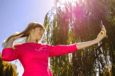 Kız selfie doğa üzerinde yapar.