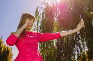 Kız selfie doğa üzerinde yapar.