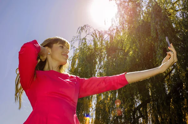 Kız selfie doğa üzerinde yapar.