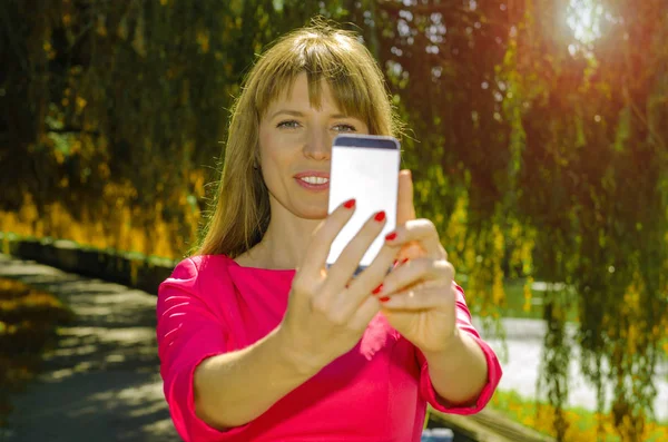 Kız selfie doğa üzerinde yapar.