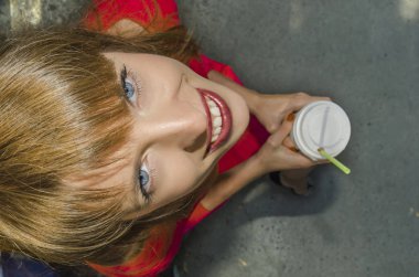 Kırmızı elbiseli kız ile bir kağıt bardak oturur 