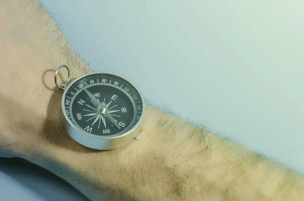 Hand with a compass on a blue background — Stock Photo, Image