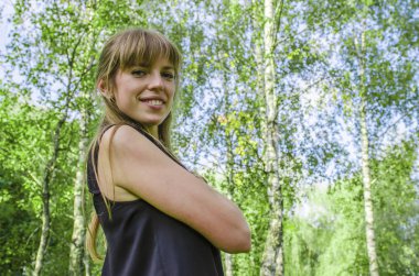 Yeşil bir arka plan ile şirin ve gülümseyen bir kadın portresi ağacının yaprakları.