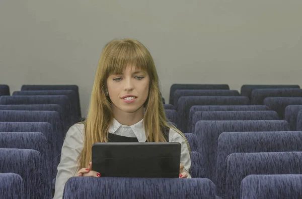 Chica con una tableta en una sala de conferencias vacía — Foto de Stock