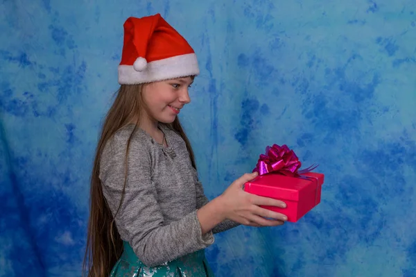 Menina em Santa chapéu com uma caixa de presente vermelho — Fotografia de Stock