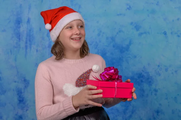 Menina em Santa chapéu com uma caixa de presente vermelho — Fotografia de Stock