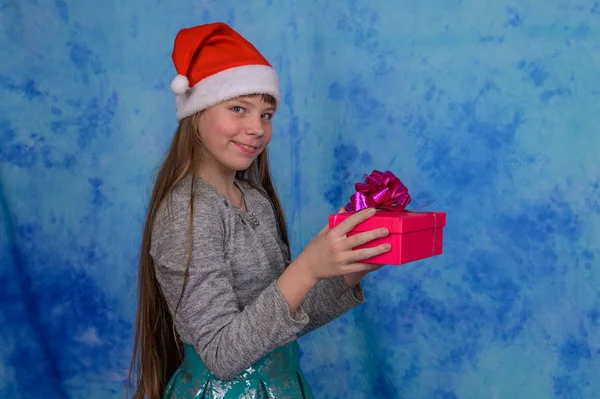 Menina em Santa chapéu com uma caixa de presente vermelho — Fotografia de Stock