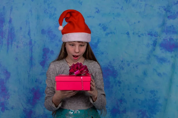 Chica en Santa sombrero con recibió una caja de regalo roja — Foto de Stock