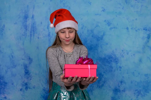 Menina em Santa chapéu com recebeu uma caixa de presente vermelho — Fotografia de Stock