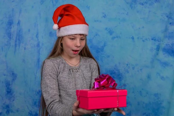 Chica en Santa sombrero con recibió una caja de regalo roja — Foto de Stock