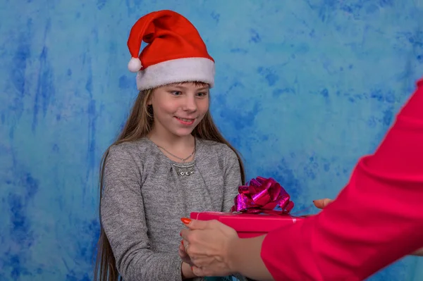 Chica en Santa sombrero con recibió una caja de regalo roja — Foto de Stock