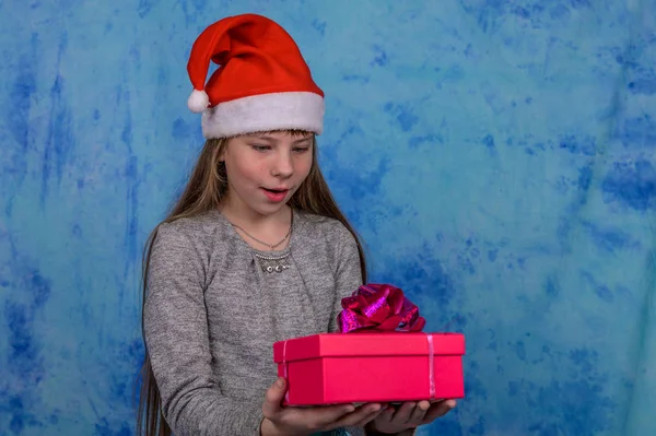 Chica en Santa sombrero con recibió una caja de regalo roja — Foto de Stock