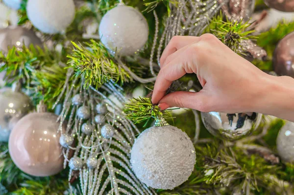 Mão feminina decora uma árvore de Natal — Fotografia de Stock