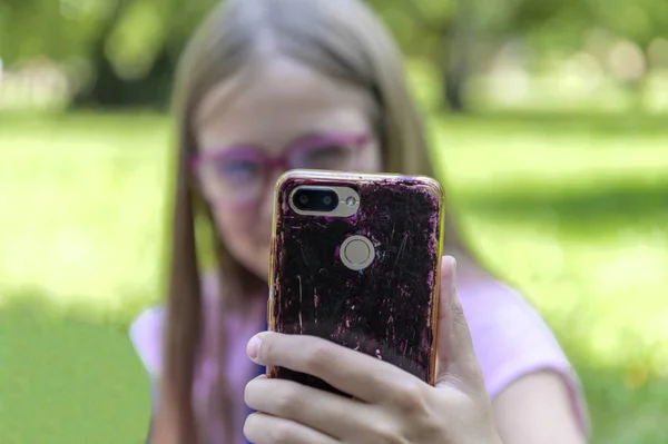 Menina com óculos leva uma selfie ao ar livre — Fotografia de Stock