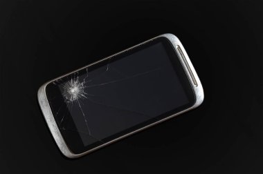 Siyah arka planda kırık ekranlı akıllı telefon