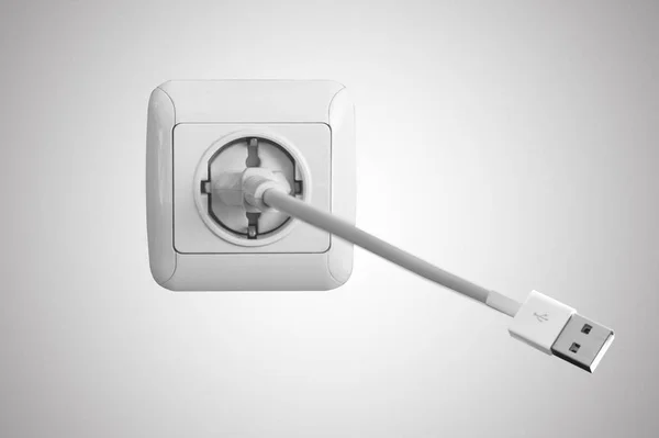 Біла електрична розетка на стіні і шнур USB — стокове фото