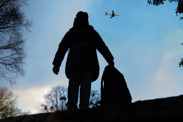 Silhouette Eines Mädchens Mit Rucksack Das Ein Flugzeug Himmel Betrachtet — Stockfoto