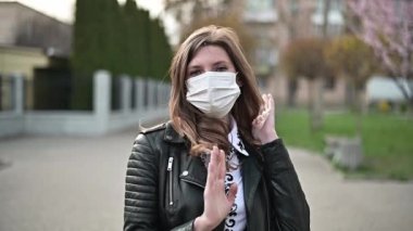 Virüs maskesi. COVID-19. Koronavirüsü önlemek için kamusal alanda yürüyen kadın yüz koruması takıyor. Güzel ve mutlu bir kadın sokakta tıbbi maske takıyor..