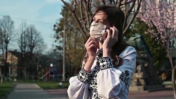 Γυναίκα Χειρουργική Μάσκα Μιλάει Στο Τηλέφωνο Ιατρική Μάσκα Προστασία Από — Αρχείο Βίντεο