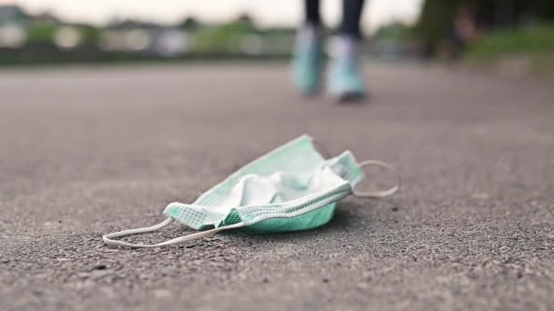 Een Vrouw Sneakers Stapt Een Medisch Masker Weg Het Einde — Stockvideo