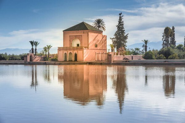 Ruins of the Saadian garden pavilion with the snow capped Atlas mountains in the background and the reflecting pool in the foreground, Menara Gardens, Marrakech, Morocco