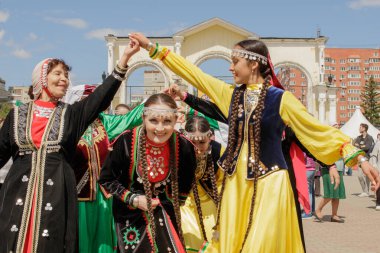 Yekaterinburg, Rusya, 15 Haziran 2019. Ulusal elbise giymiş kadınlar halk dansları yapıyor. Yıllık Tatarlar ve Bashkirs Sabantuy bayramı şehir parkında.