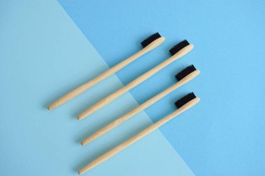 Açık mavi ve mavi arkaplan üzerinde bambu diş fırçaları ile düz konum