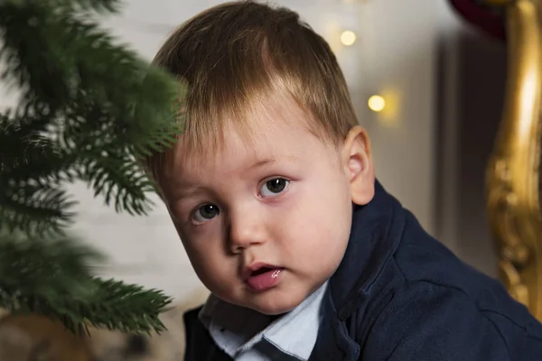 Portrait of the beautiful kid near a Christmas tree — Stock Photo, Image