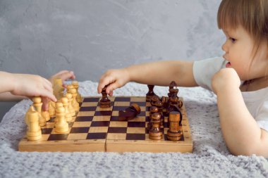 Küçük bir kız kendi başına odasında satranç oynuyor.