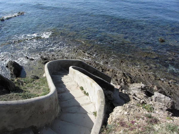 Escadaria de betão até ao mar. Escada espiral descida para a água. Toscana, Itália — Fotografia de Stock