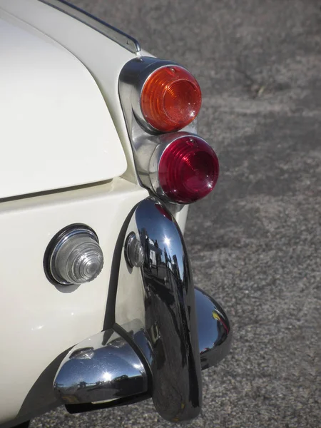 Rear of an old british classic car . Particular view of right tail light and shiny chrome bumper . The car is a Triumph TR3 model produced between 1955 and 1962 — Stock Photo, Image