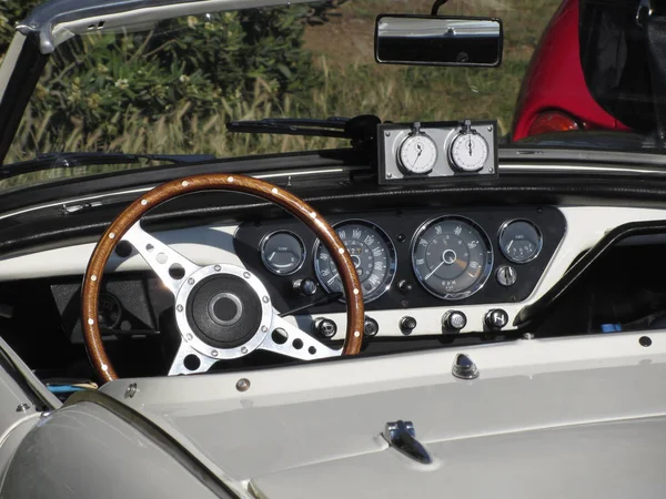 Dashboard of an old british classic car . Particular view of steering wheel and vehicle instrument panel . The car is a Triumph TR3 model produced between 1955 and 1962 — Stok fotoğraf