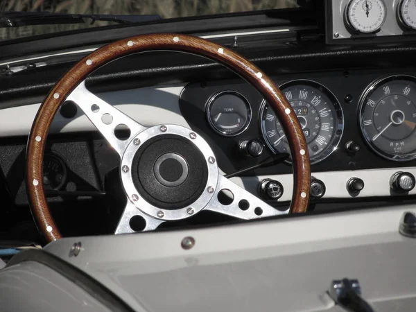 Tablero de instrumentos de un viejo coche clásico británico. Vista particular del volante y del panel de instrumentos del vehículo. El coche es un modelo Triumph TR3 producido entre 1955 y 1962 — Foto de Stock