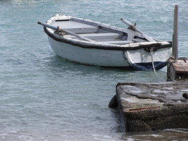 Denizde bir limana demirlemiş tek bir tahta kayık. Toskana, İtalya