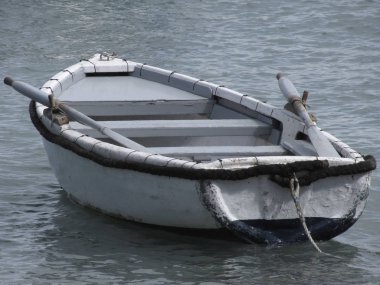 Denizde bir limana demirlemiş tek bir tahta kayık. Toskana, İtalya