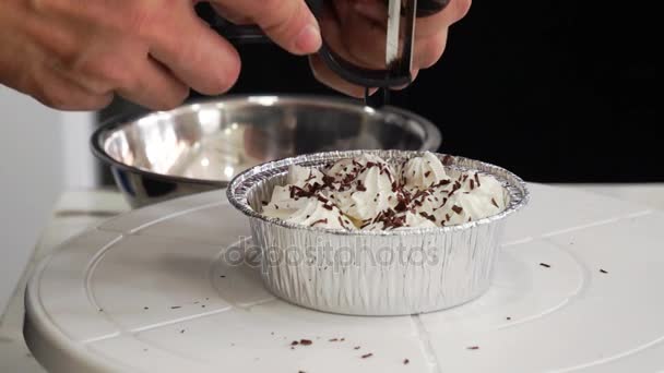 Nahaufnahme-Video von feinen Schokoladenspänen, die von Hand gemacht werden, mit einem Messer vom Block abgeschnitten, auf Augenhöhe, auf Kuchen, — Stockvideo