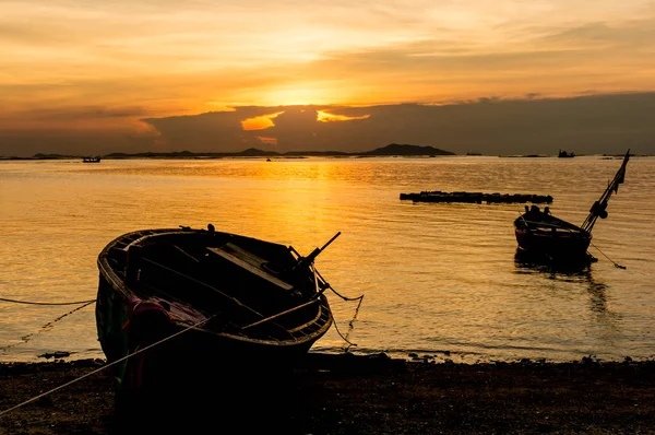 Silhouete kleine vissersboten op zee tijdens zonsondergang en wolken. — Stockfoto
