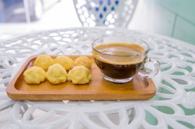 Pasta pasta veya krem Puffs veya kahve Kupası beyaz masada ahşap plaka ile profiterol.